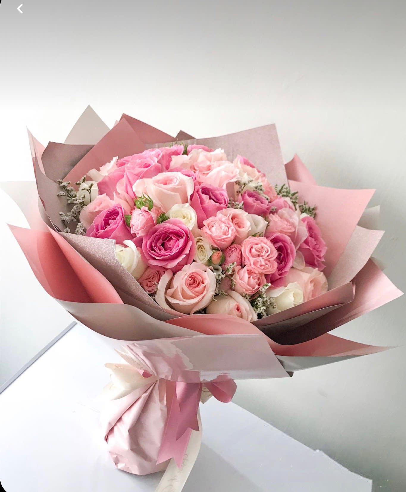 Pink and blush rose bouquet wrapped in layered paper
