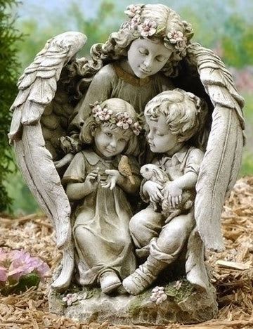 Stone angel statue of three children with flowers and a rabbit