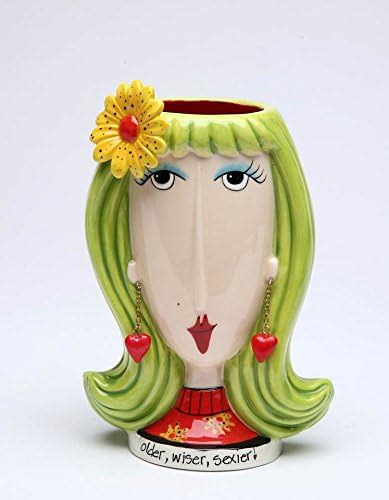 Decorative ceramic vase shaped like a woman's face with a flower accent