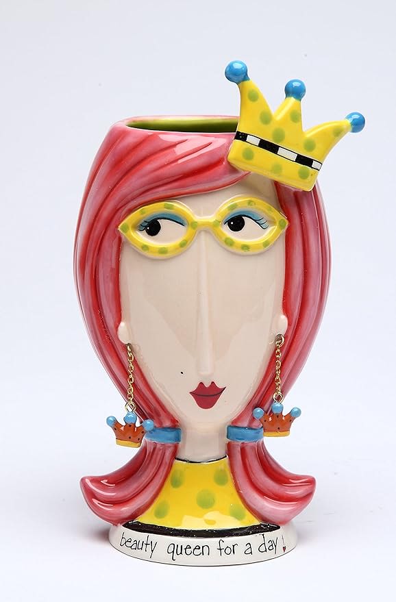 Decorative ceramic face vase with pink hair and a crown