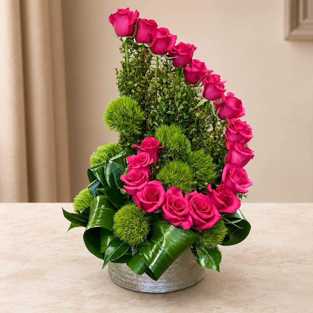 Pink roses arranged in a silver vase with bright green accents.