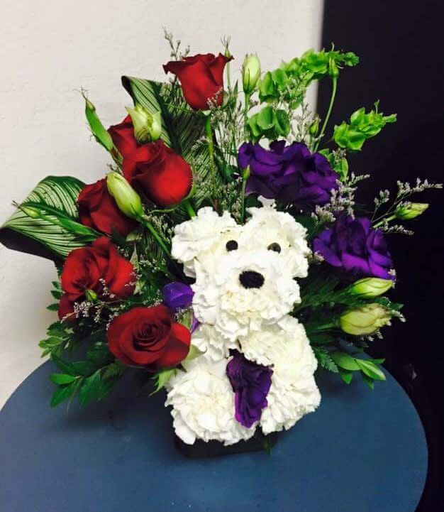 Bouquet with red and purple roses and a white teddy bear made of flowers