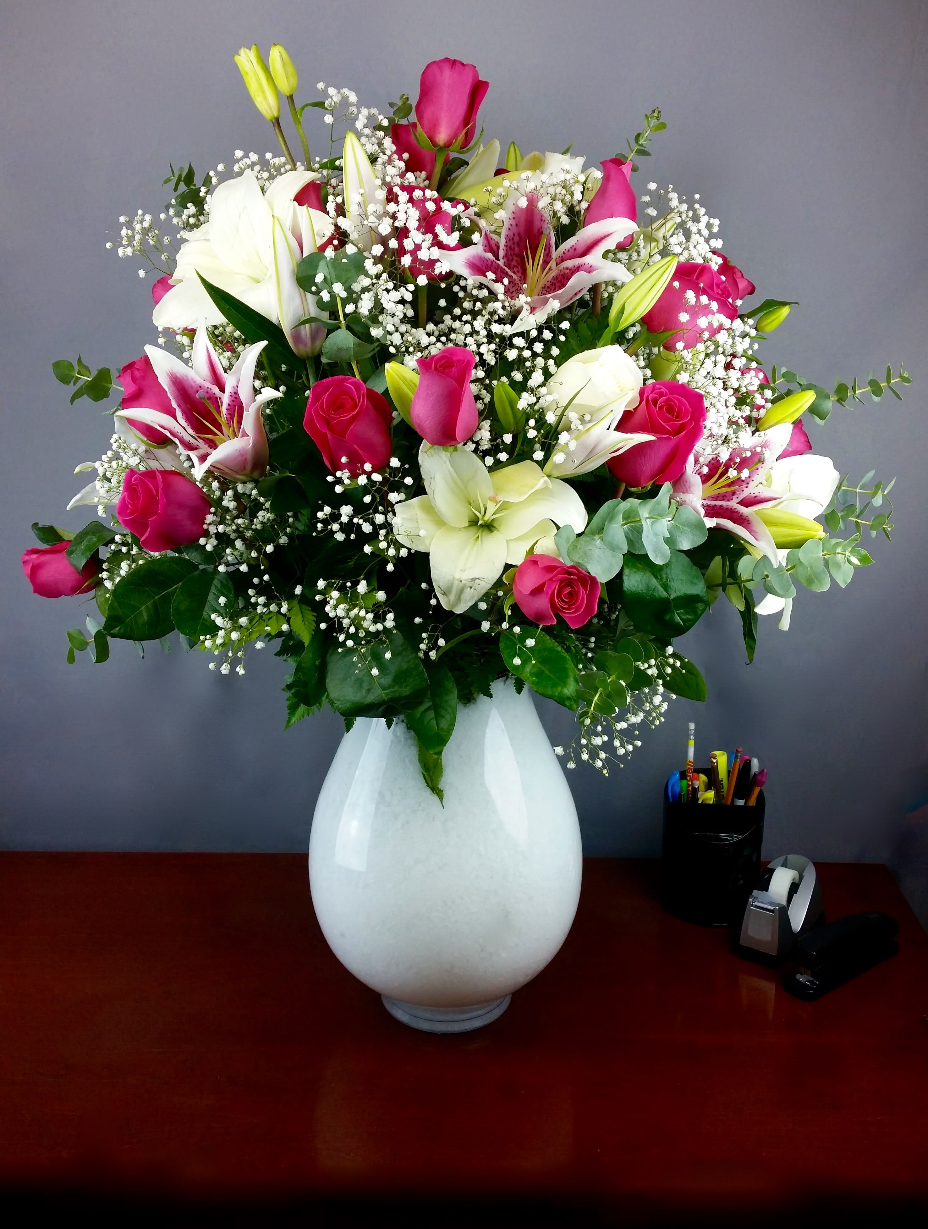 Pink roses and white lilies in a white vase