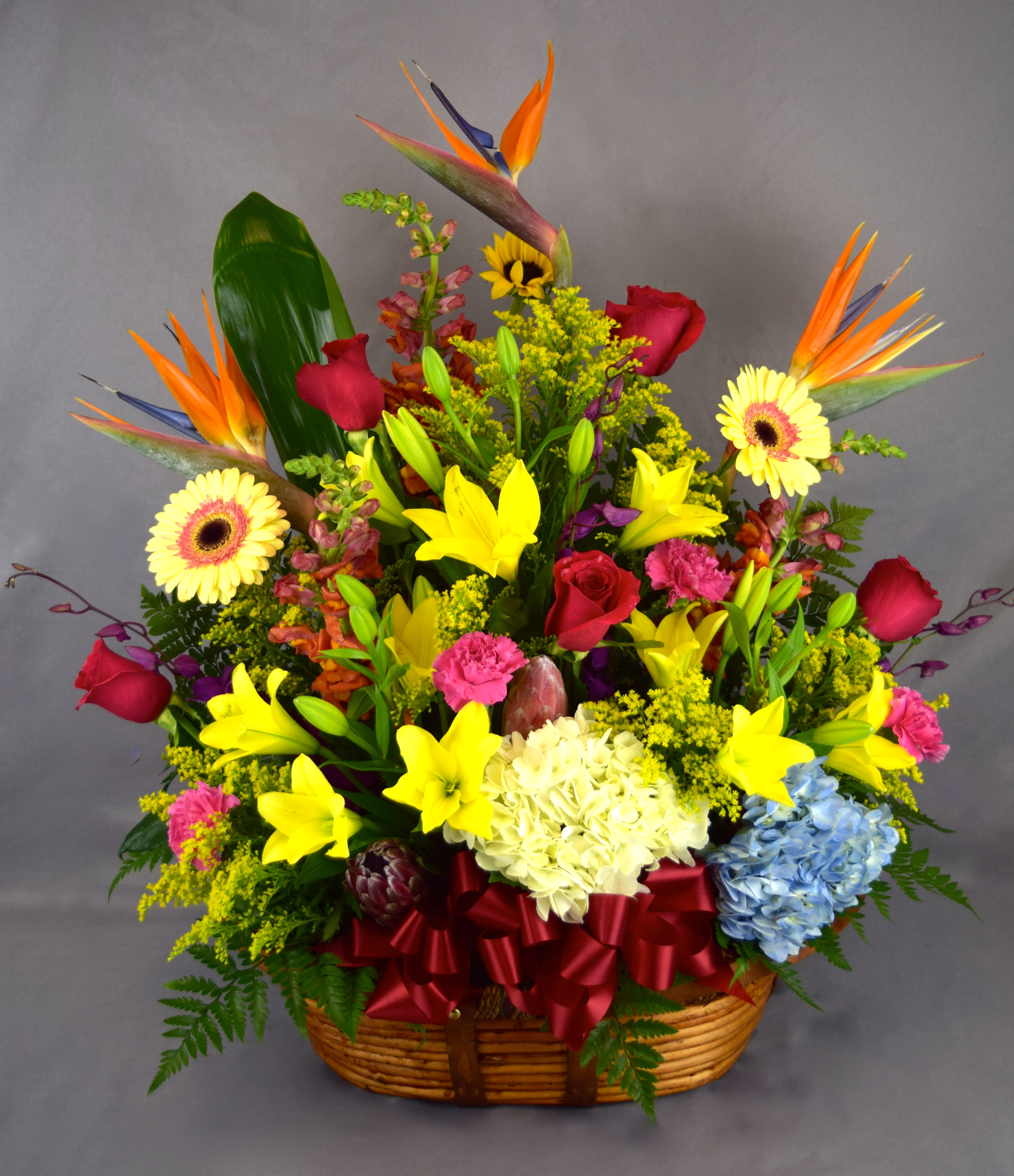 Colorful tropical flower basket with lilies, roses, and gerbera daisies