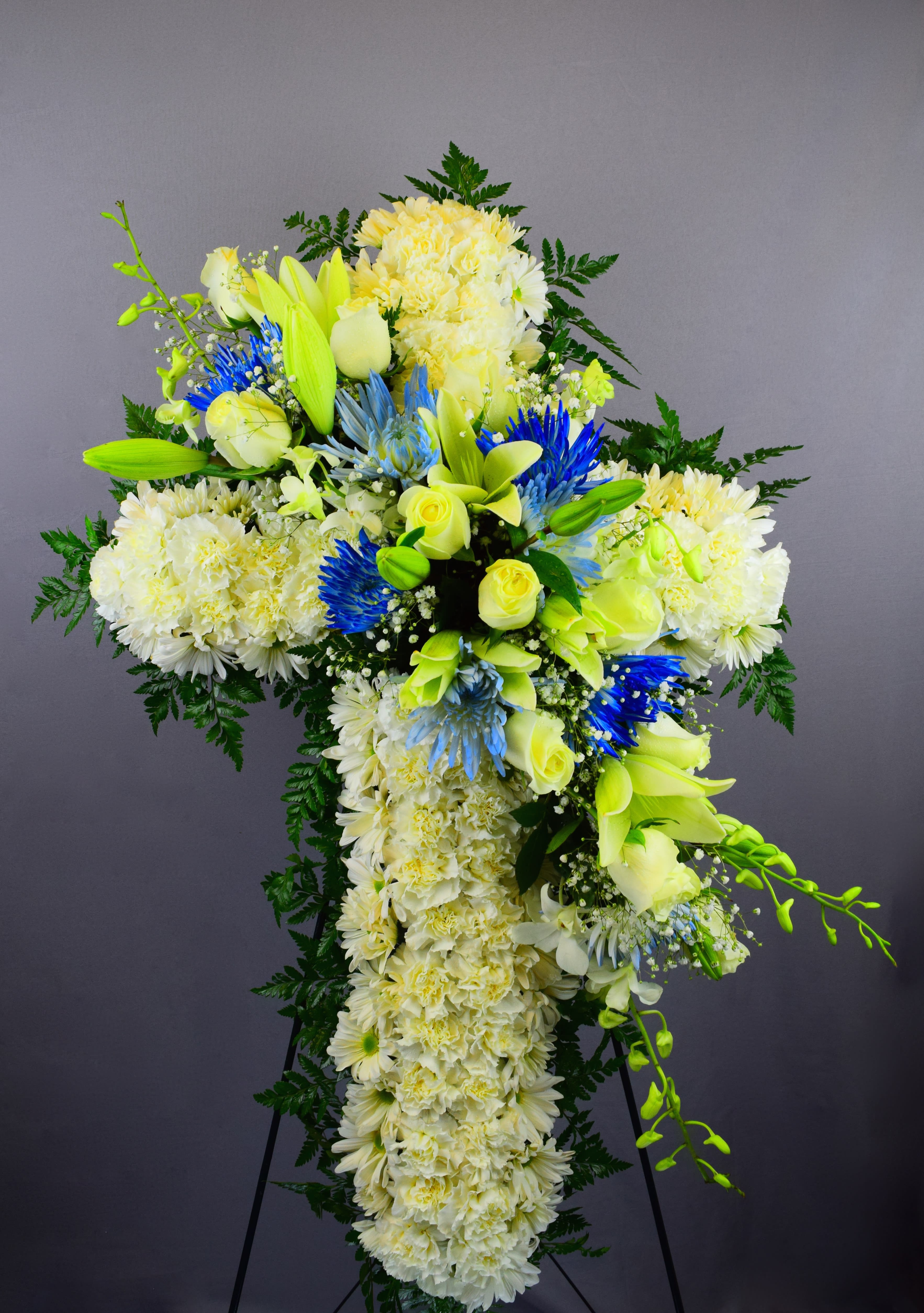Large white and yellow floral standing spray with blue accents
