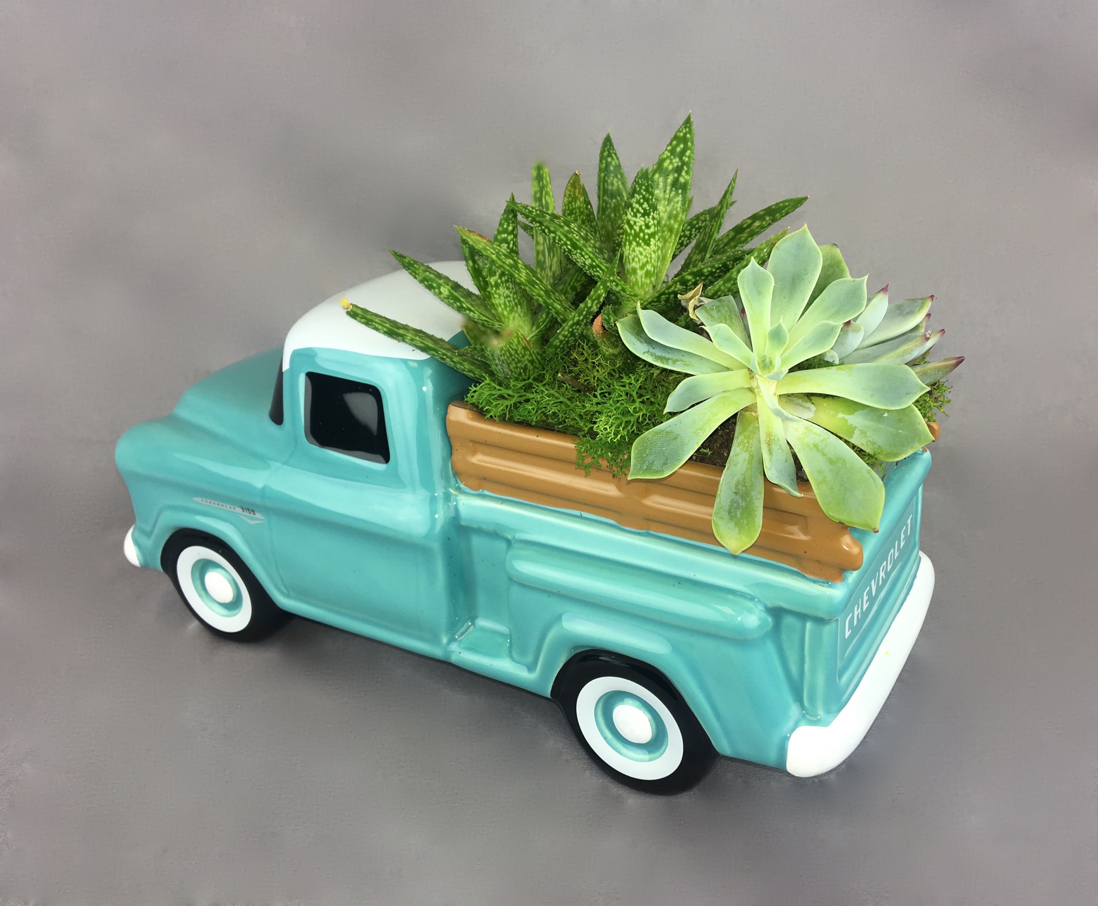 Succulent arrangement in a turquoise ceramic truck planter