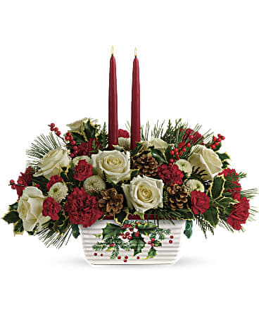 Holiday centerpiece with red and white roses in a white container and two red candles
