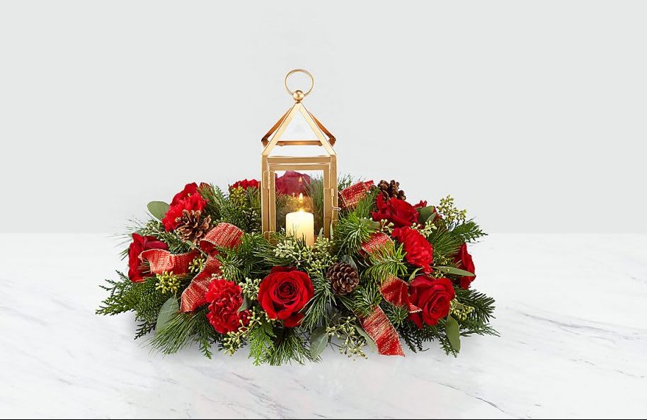 Red rose centerpiece with a gold lantern and candle