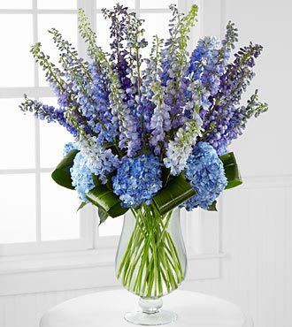 Blue and lavender flower arrangement in a clear glass vase