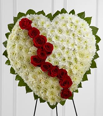 Heart-shaped floral spray with white flowers and a diagonal line of red roses