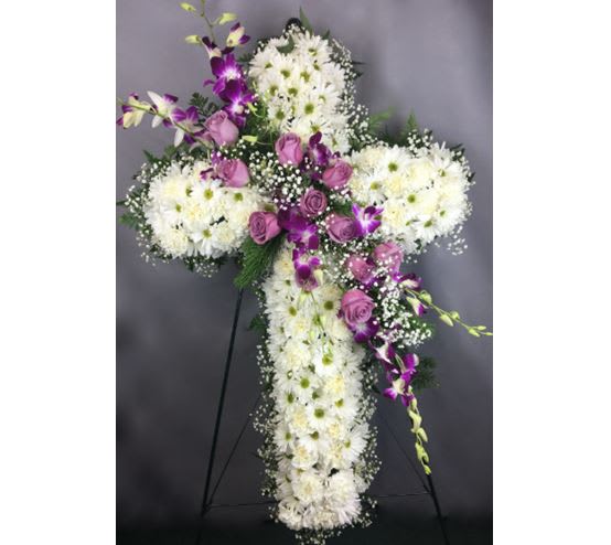 White and purple floral cross on a stand