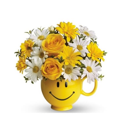 Yellow smiley-face mug filled with yellow roses and white daisies