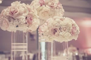 Blush and white rose arrangements in tall clear vases