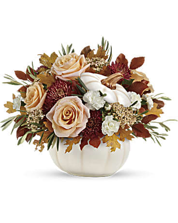 Autumn floral arrangement with peach roses in a white pumpkin vase