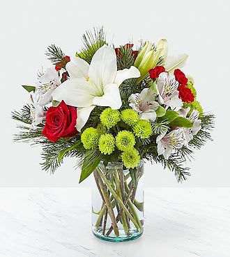 Bouquet of white lilies, red roses, and green pompons in a glass vase