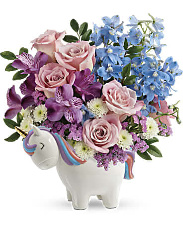 Pink and blue flowers arranged in a unicorn-shaped vase