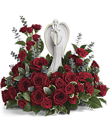 Red rose arrangement with a white angel figurine in the center