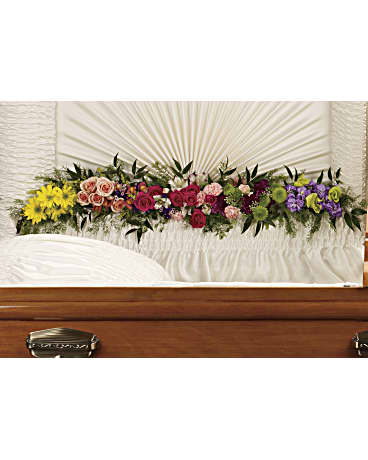 Colorful floral spray arranged across a casket