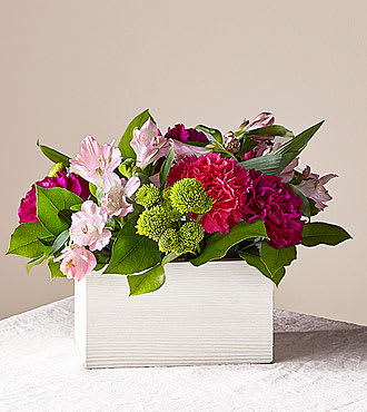 Pink and magenta flowers arranged in a white rectangular box