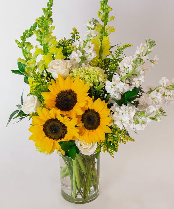 Sunflowers and white roses in a clear glass vase