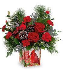 Red roses and pinecones in a holiday gift container
