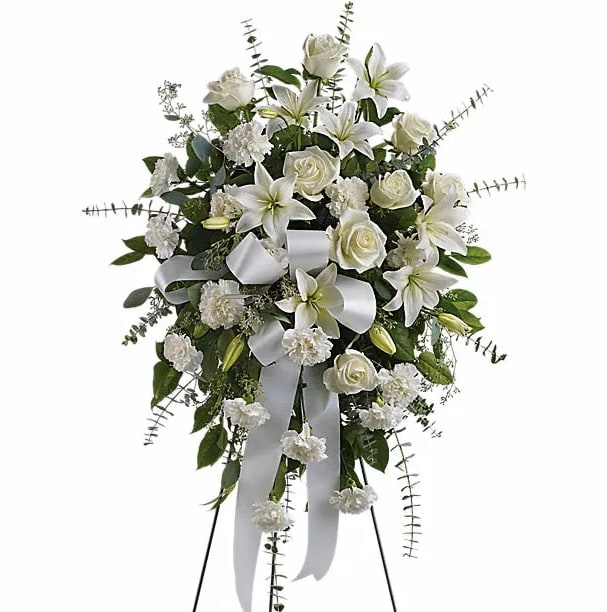 Sentiments of Serenity Spray - Beautifully simple this lovely spray of white roses lilies and carnations decorated with white satin ribbon is a tasteful way to express your sympathy. The elegant spray includes white roses white Asiatic lilies and white carnations accented with assorted greenery.