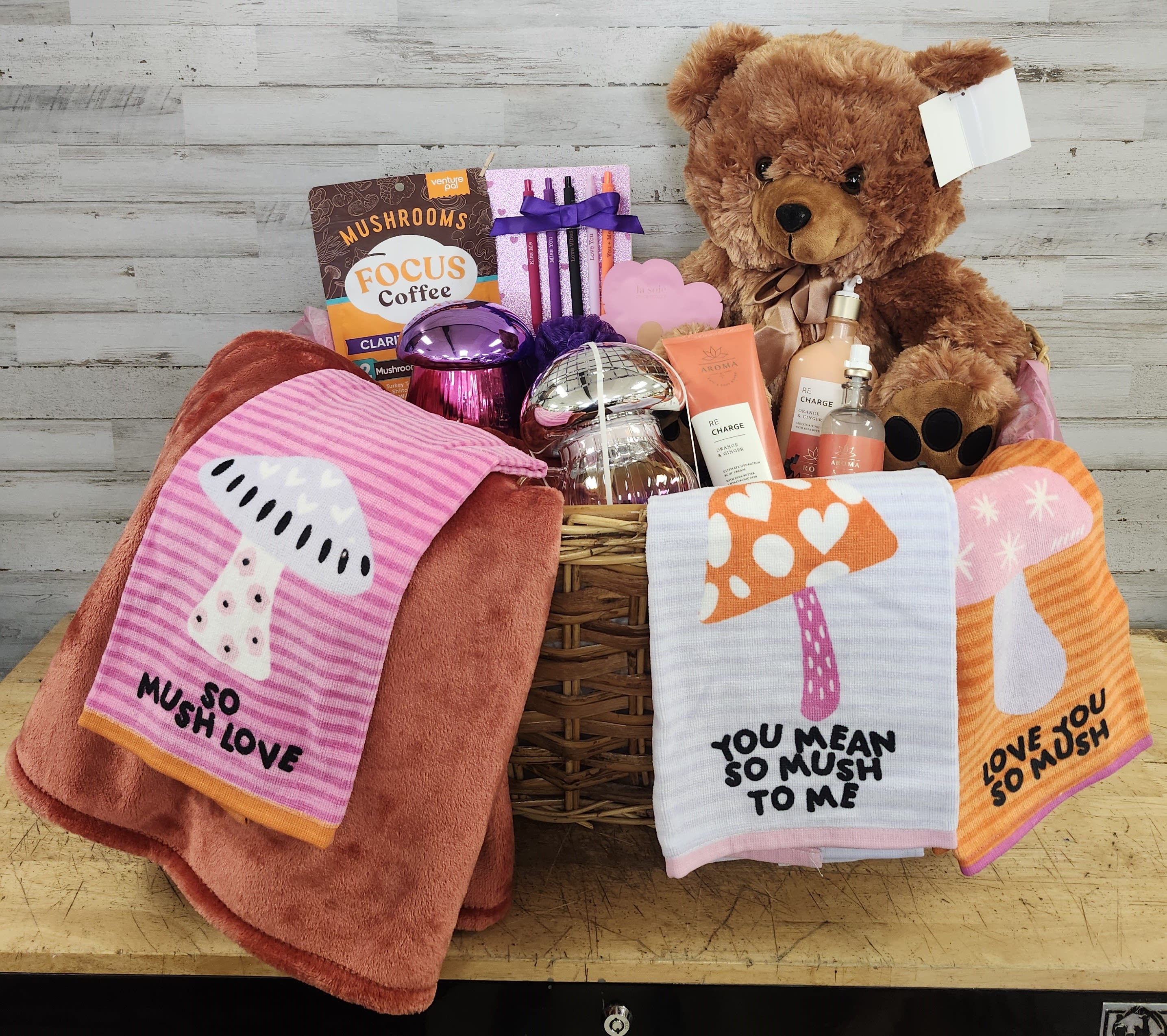 Gift basket with a teddy bear, coffee, skincare items, and mushroom-themed towels