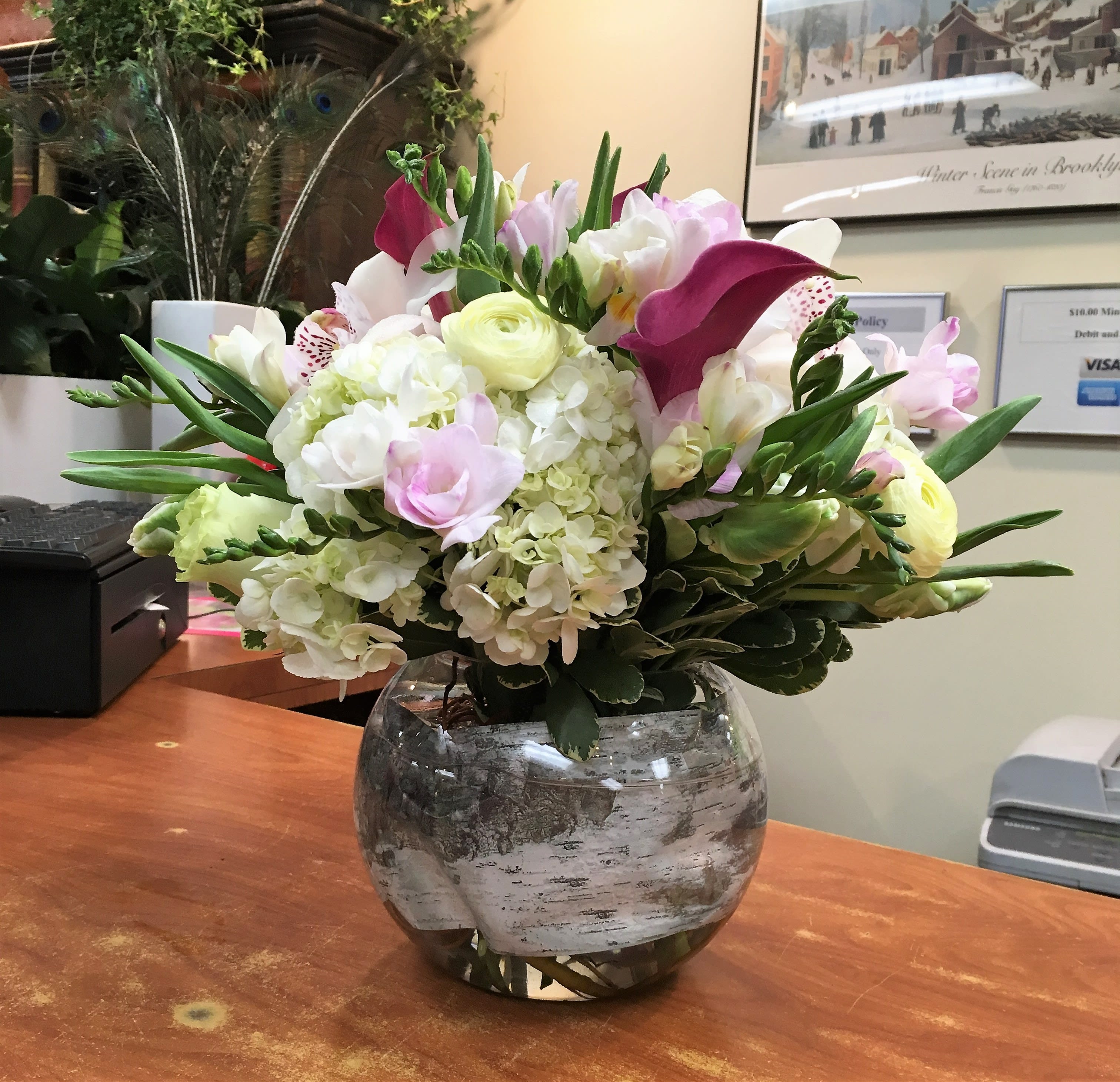 Mixed bouquet of white, pink, and purple flowers in a glass vase