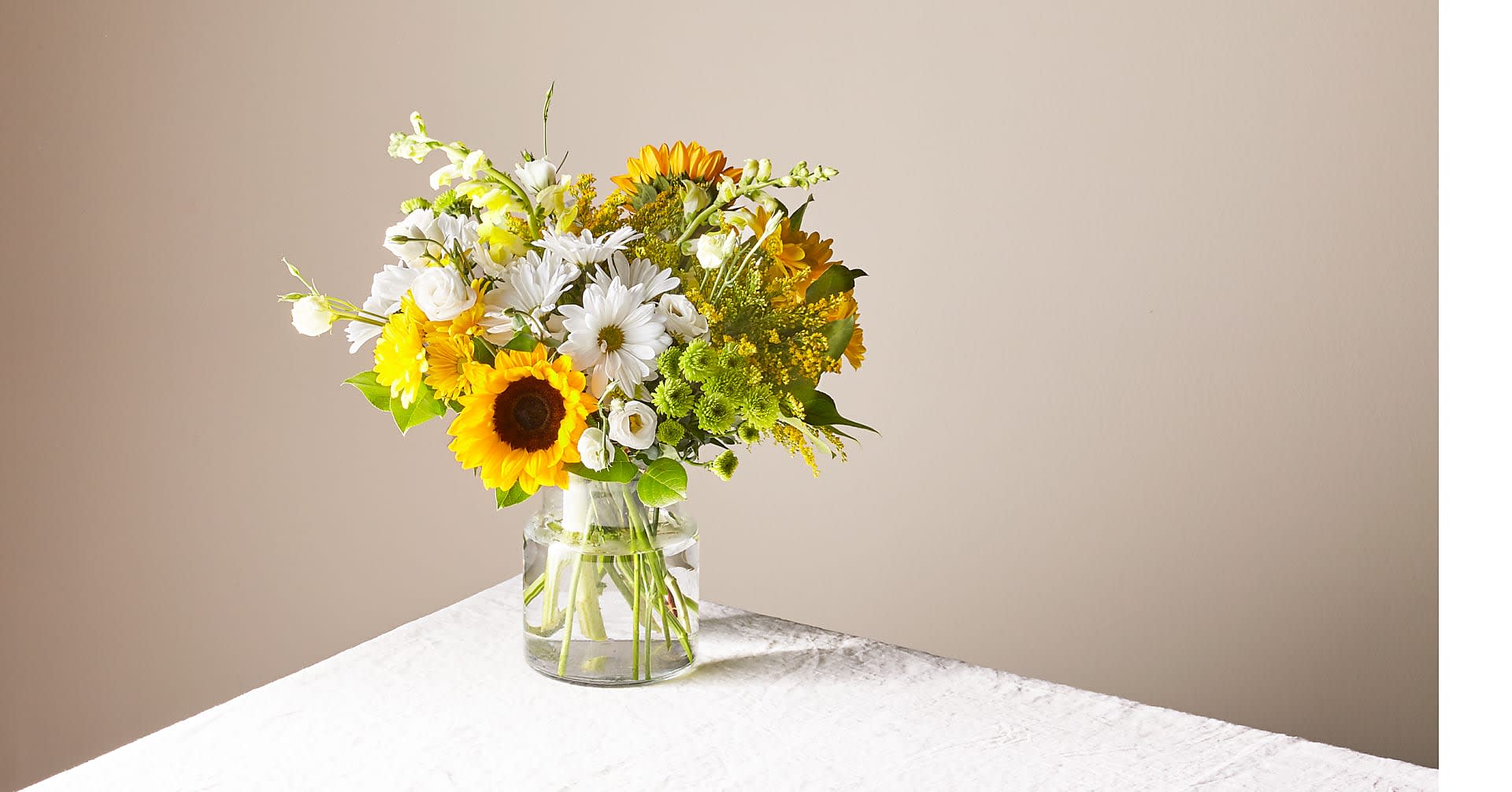 Bouquet of yellow and white flowers in a clear glass vase