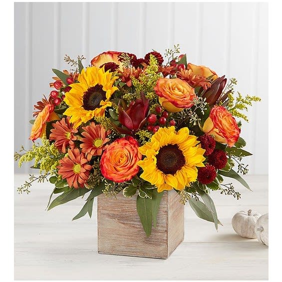 Autumn bouquet of sunflowers, roses, and daisies in a wooden box
