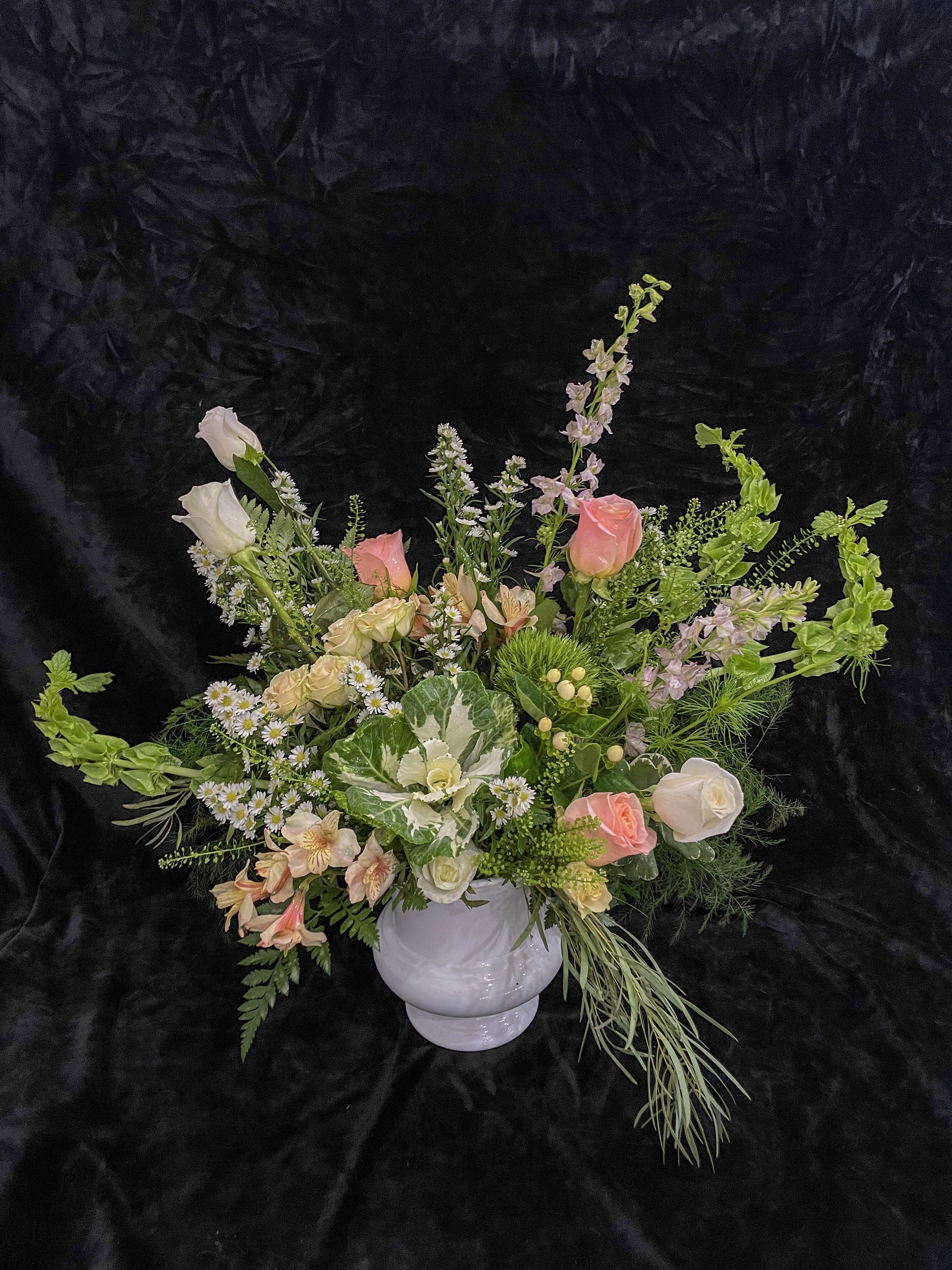 Mixed pastel floral arrangement in a white vase