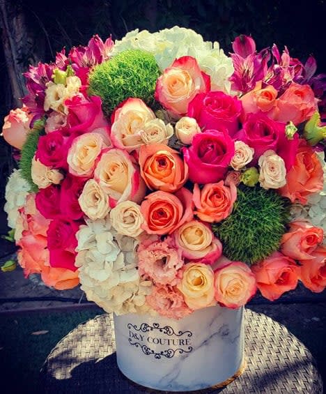 Mixed roses and hydrangeas in a white hatbox