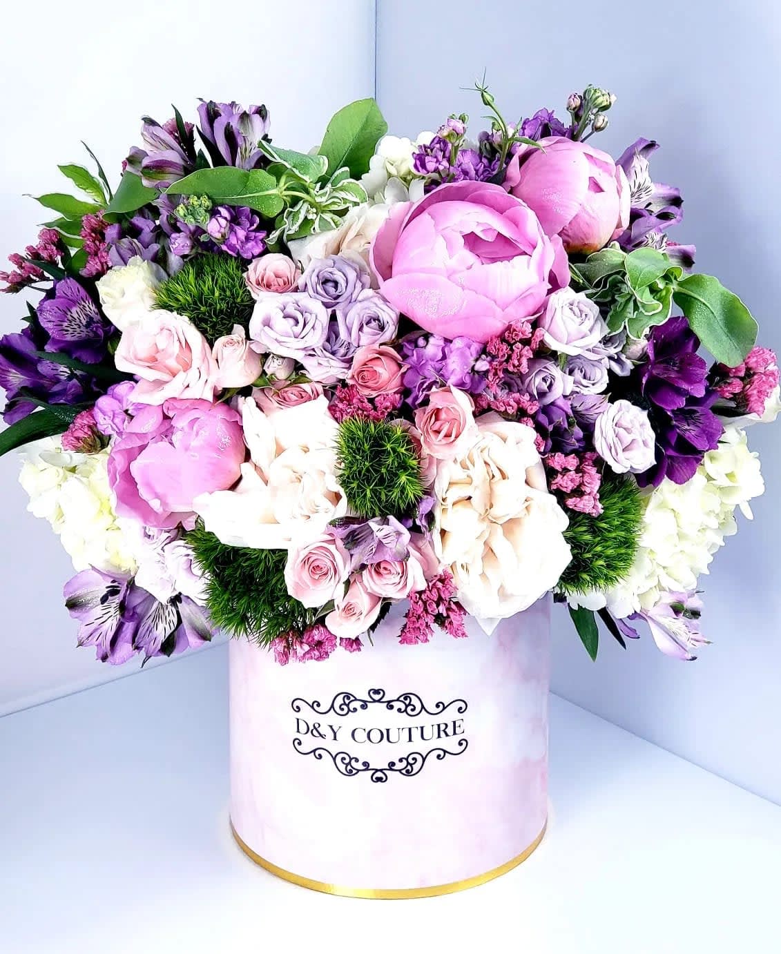 Pink and purple mixed bouquet in a round hat box
