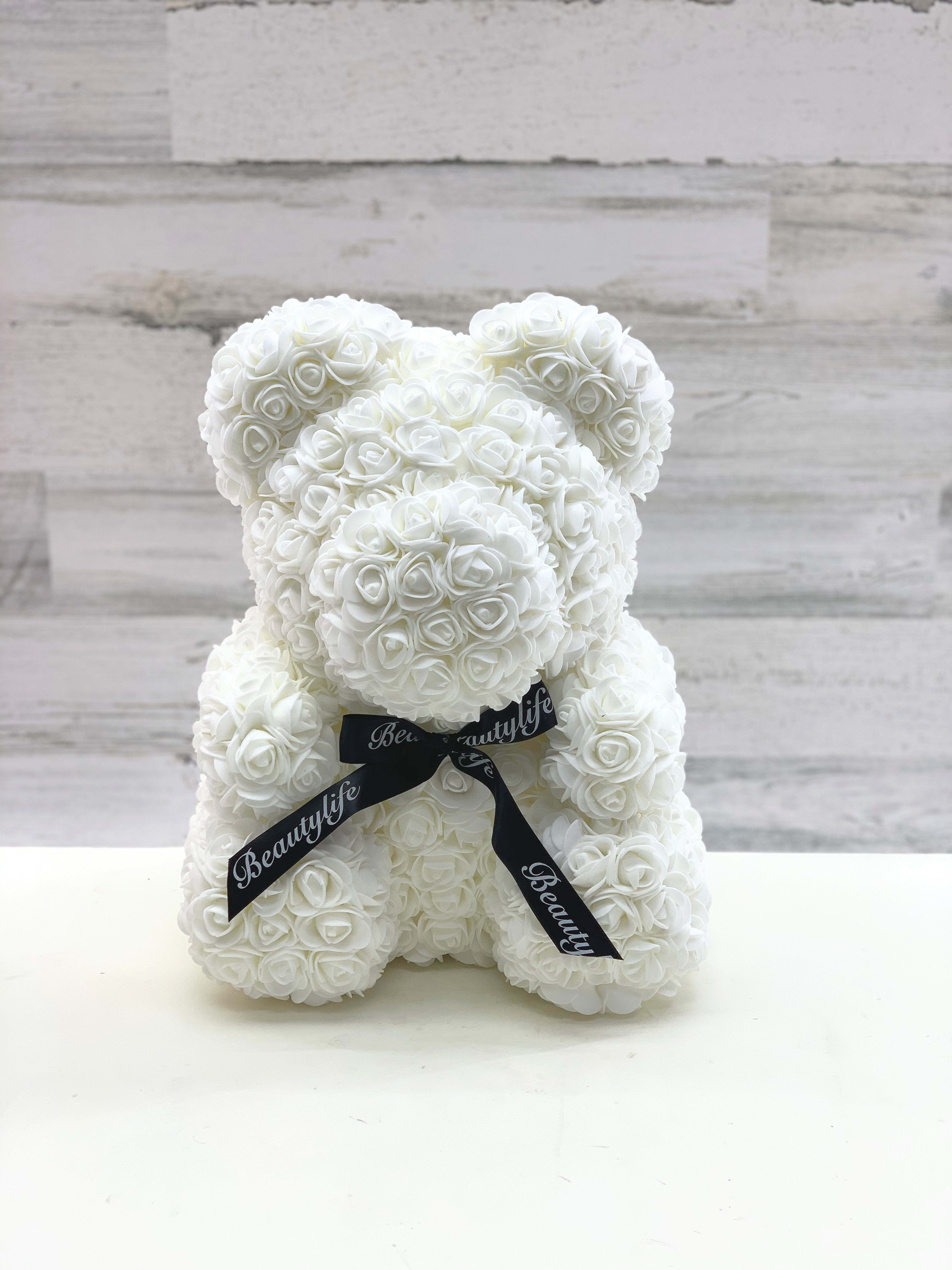 White rose teddy bear with a black ribbon bow