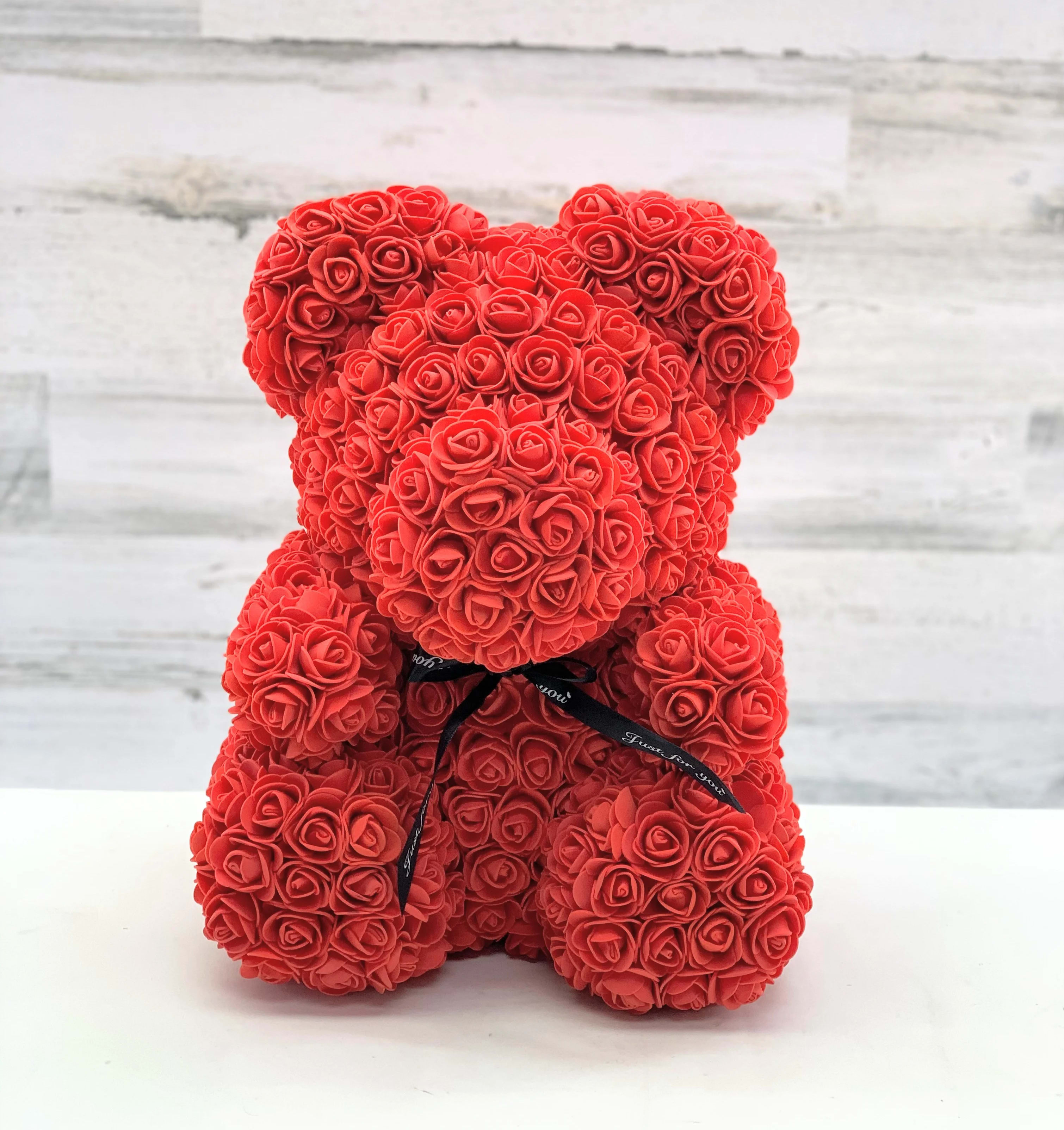 Red rose teddy bear with a black ribbon bow