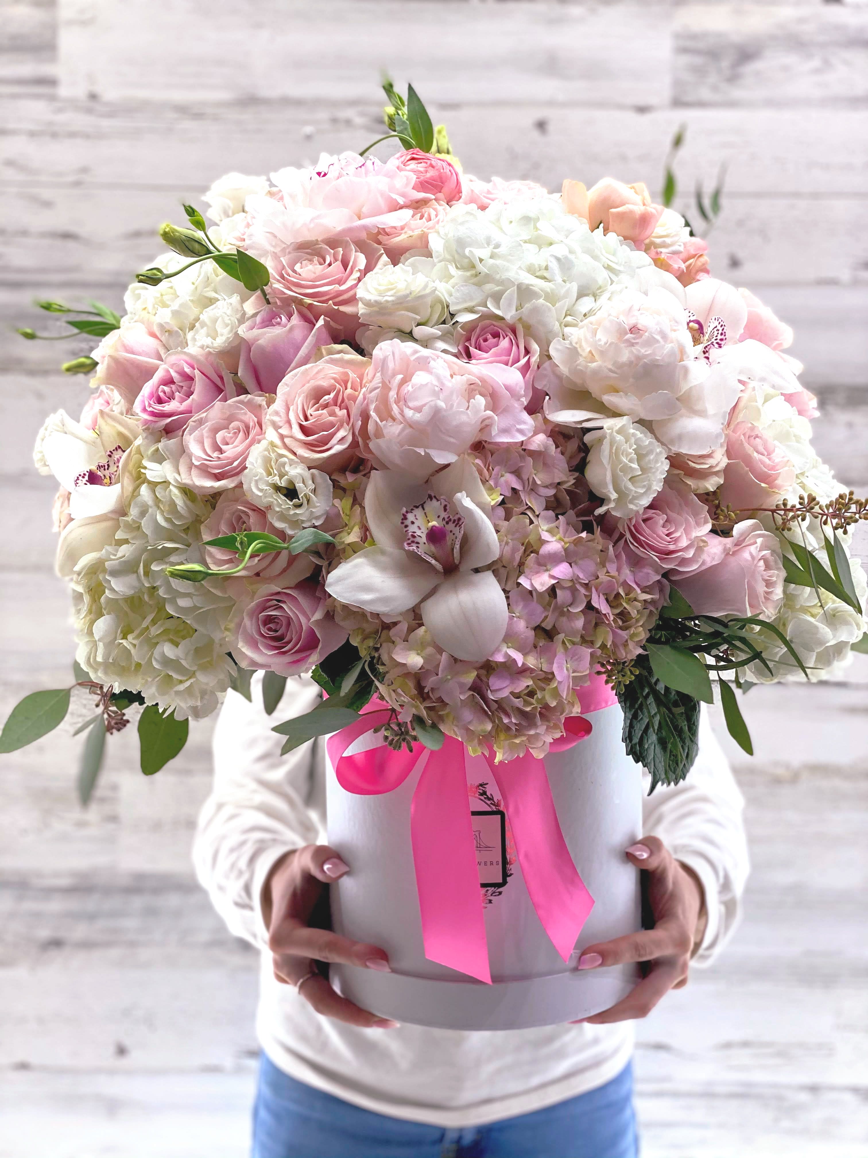 Large pastel bouquet in a white hat box with a pink ribbon