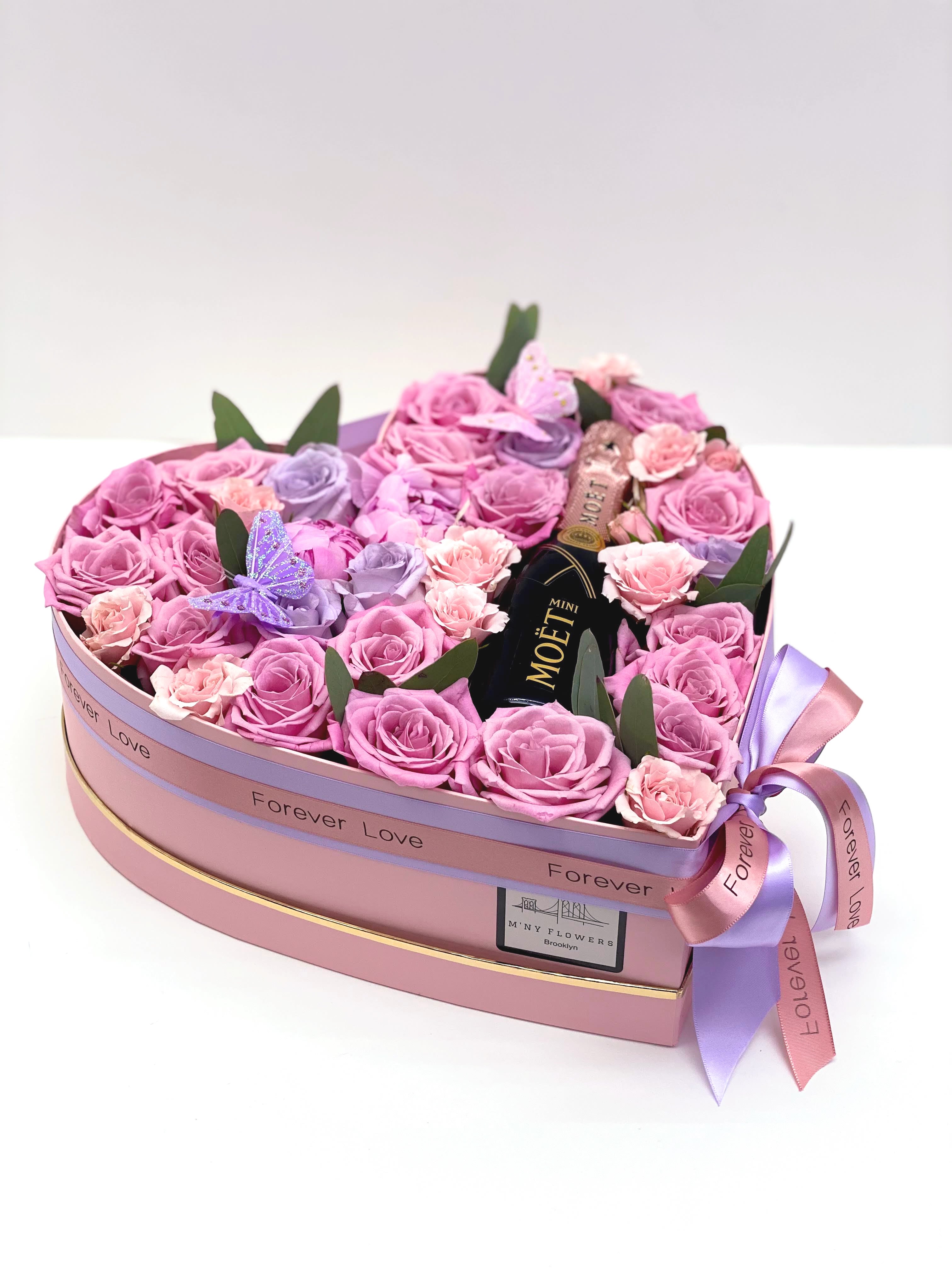 Heart-shaped box of pink and lavender roses with a mini Moët bottle