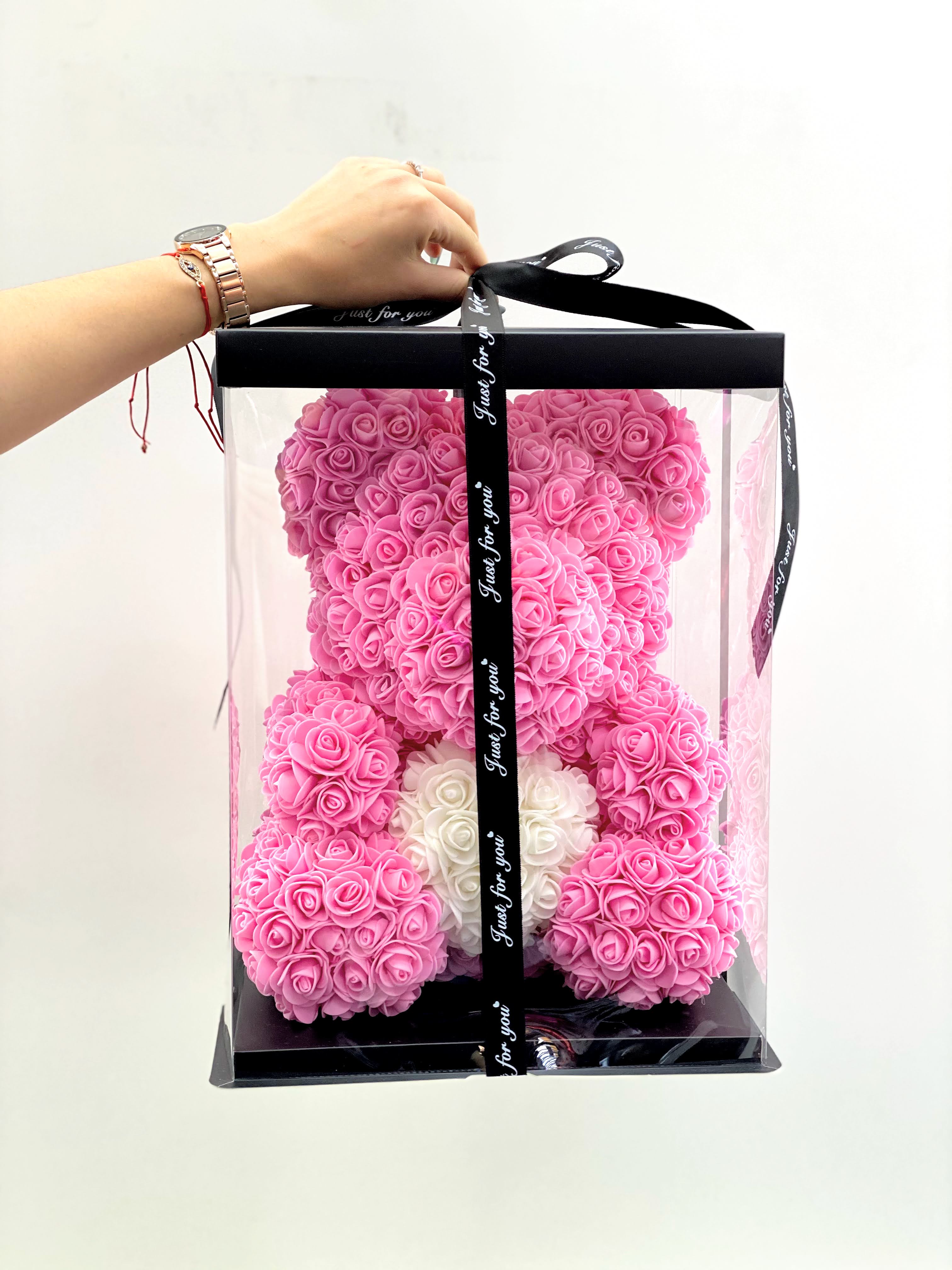 Pink rose teddy bear in a clear gift box with a black ribbon