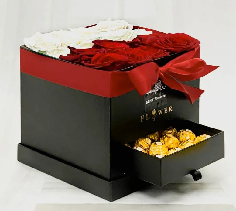 Red and white roses in a black gift box with a drawer of chocolates