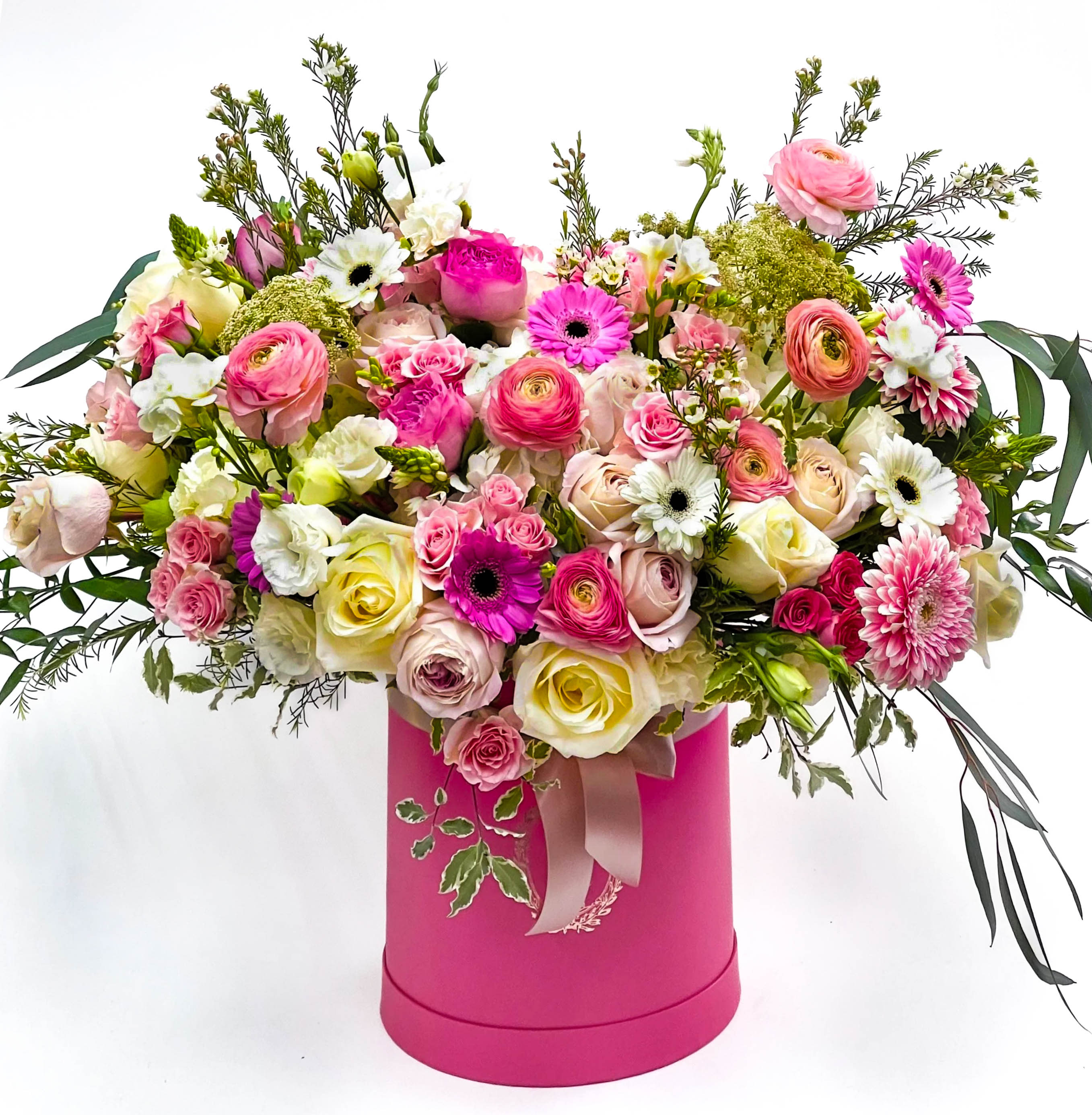 Mixed pink and white flowers in a bright pink hatbox