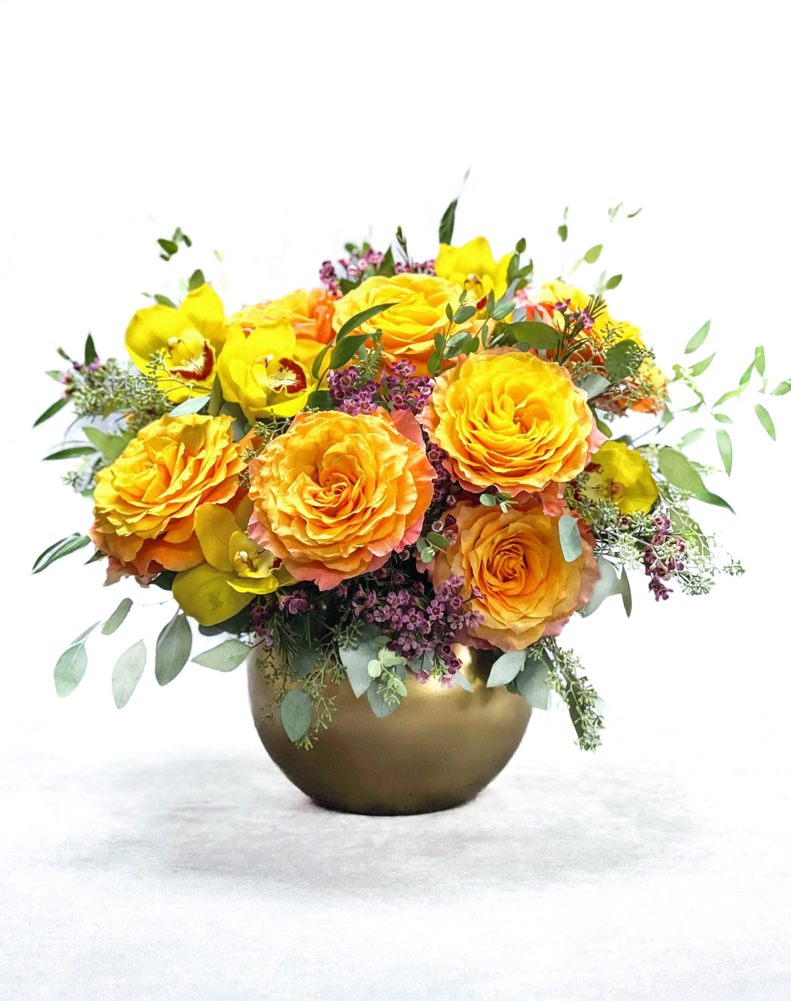 Yellow and orange rose bouquet in a gold vase