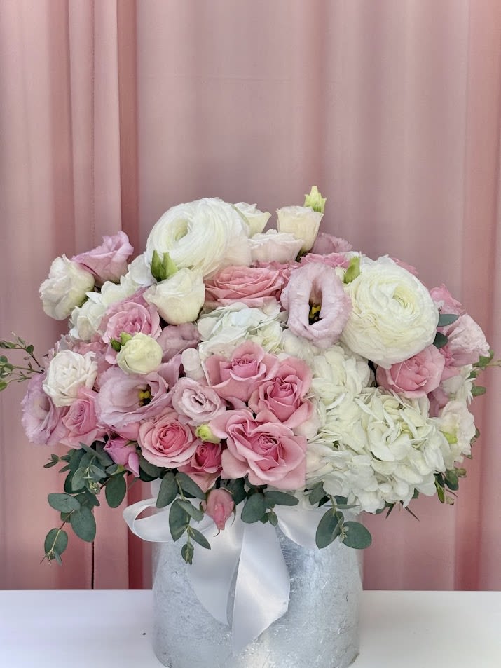 Pink and white bouquet in a silver vase with a white ribbon