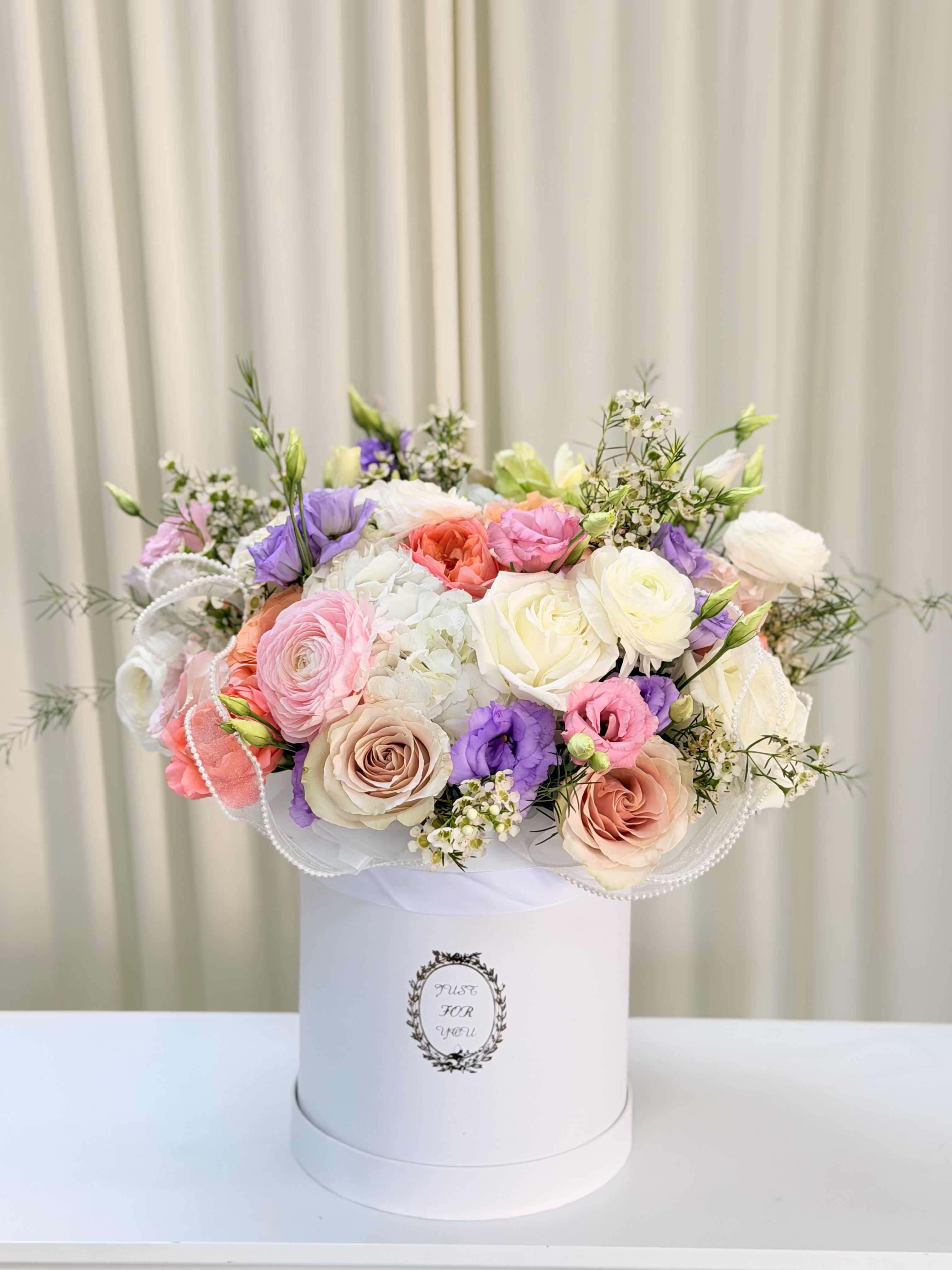 (NEW) Arta  - Transform your darlings' day into a holiday with this sophisticated and joyful arrangement. Dreamy soft pink premium roses, whimsical mixed spray roses, elegant lisianthus and seasonal greenery create a perfect symphony of colors and textures. Photo is deluxe size.