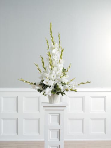 White floral arrangement in a ribbed vase on a pedestal