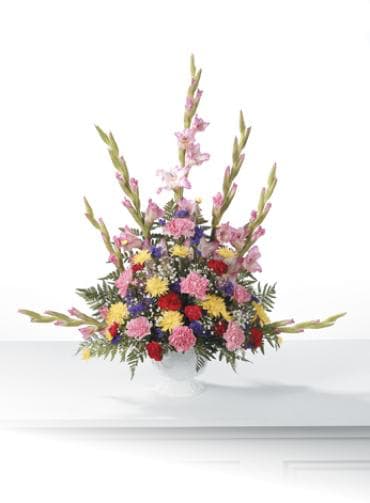 Tall mixed bouquet of pink, red, yellow, and purple flowers in a white vase