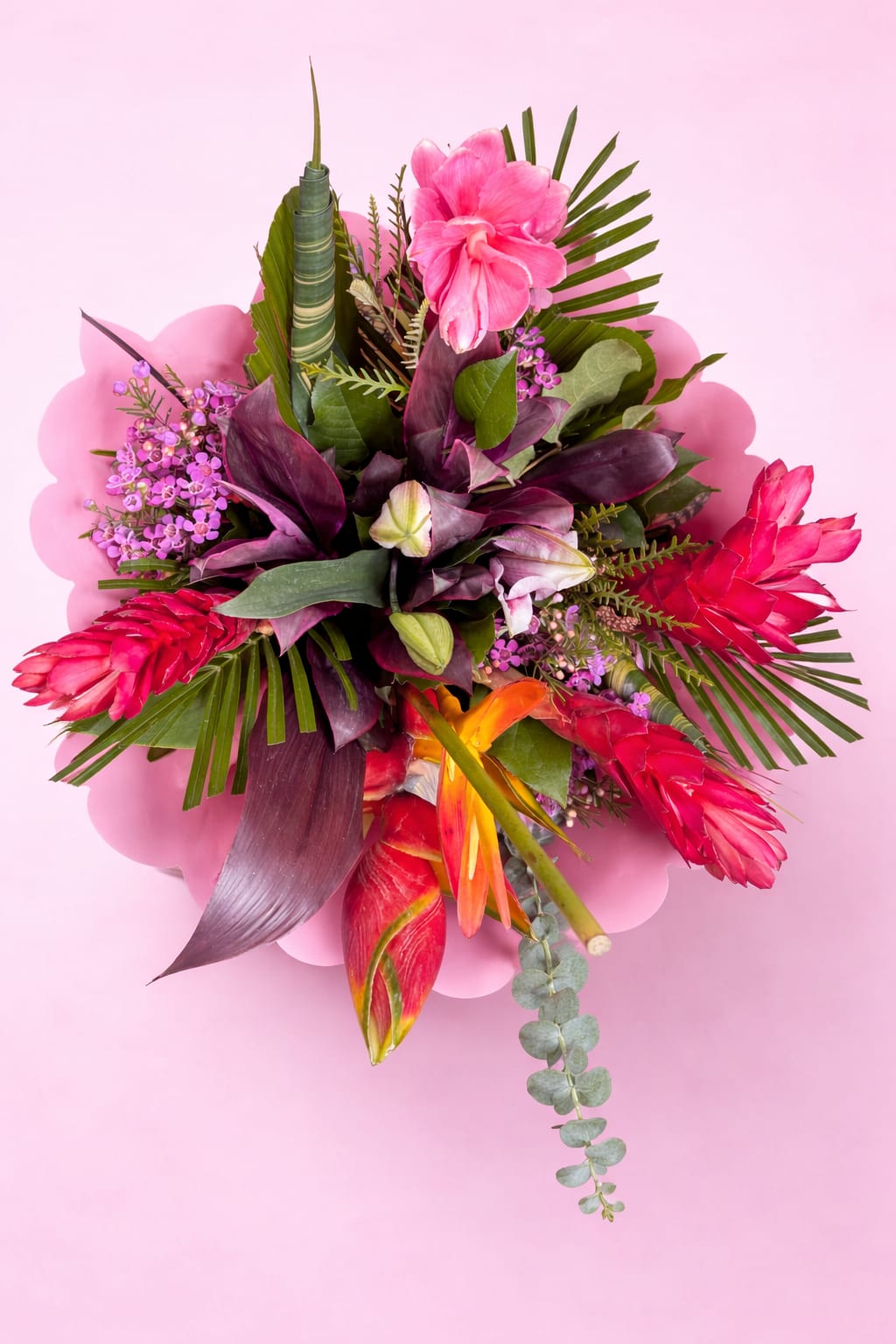 Tropical bouquet with pink and red flowers on a pink background