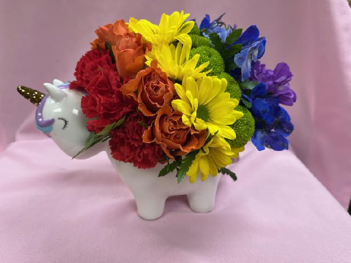 Rainbow flower arrangement in a unicorn-shaped ceramic container