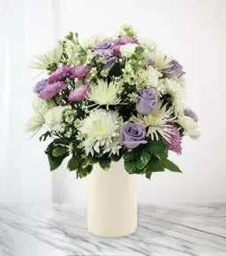 Lavender and white bouquet in a cream vase