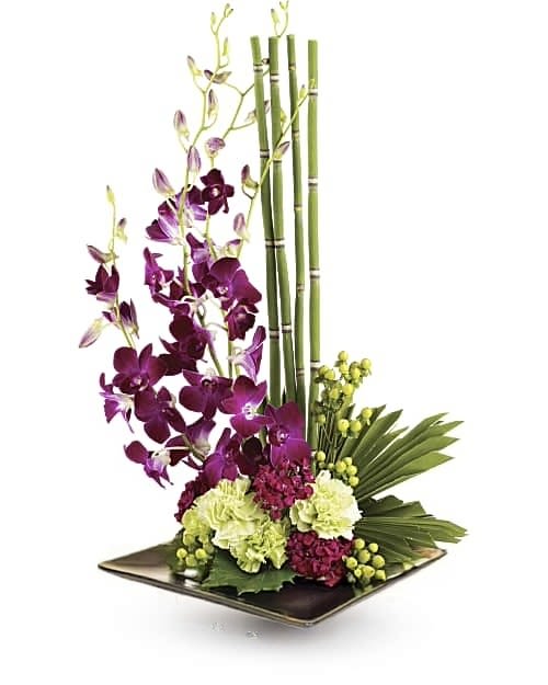 Zen Artistry - Looking more like modern sculpture than a floral arrangement, this striking bouquet surprises with delicate purple orchids, mini bamboo and a colorful mix of blooms served up in a black-colored square- dish sure to improve any room's feng shui.