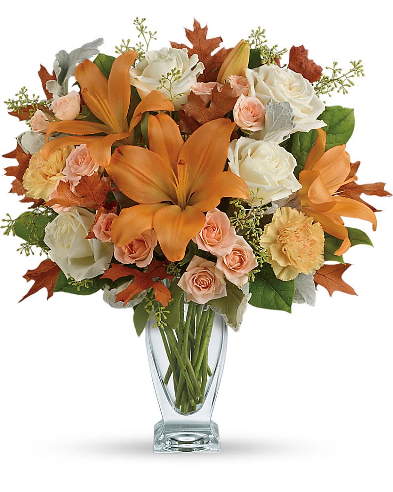 Orange lilies and white roses in a clear glass vase